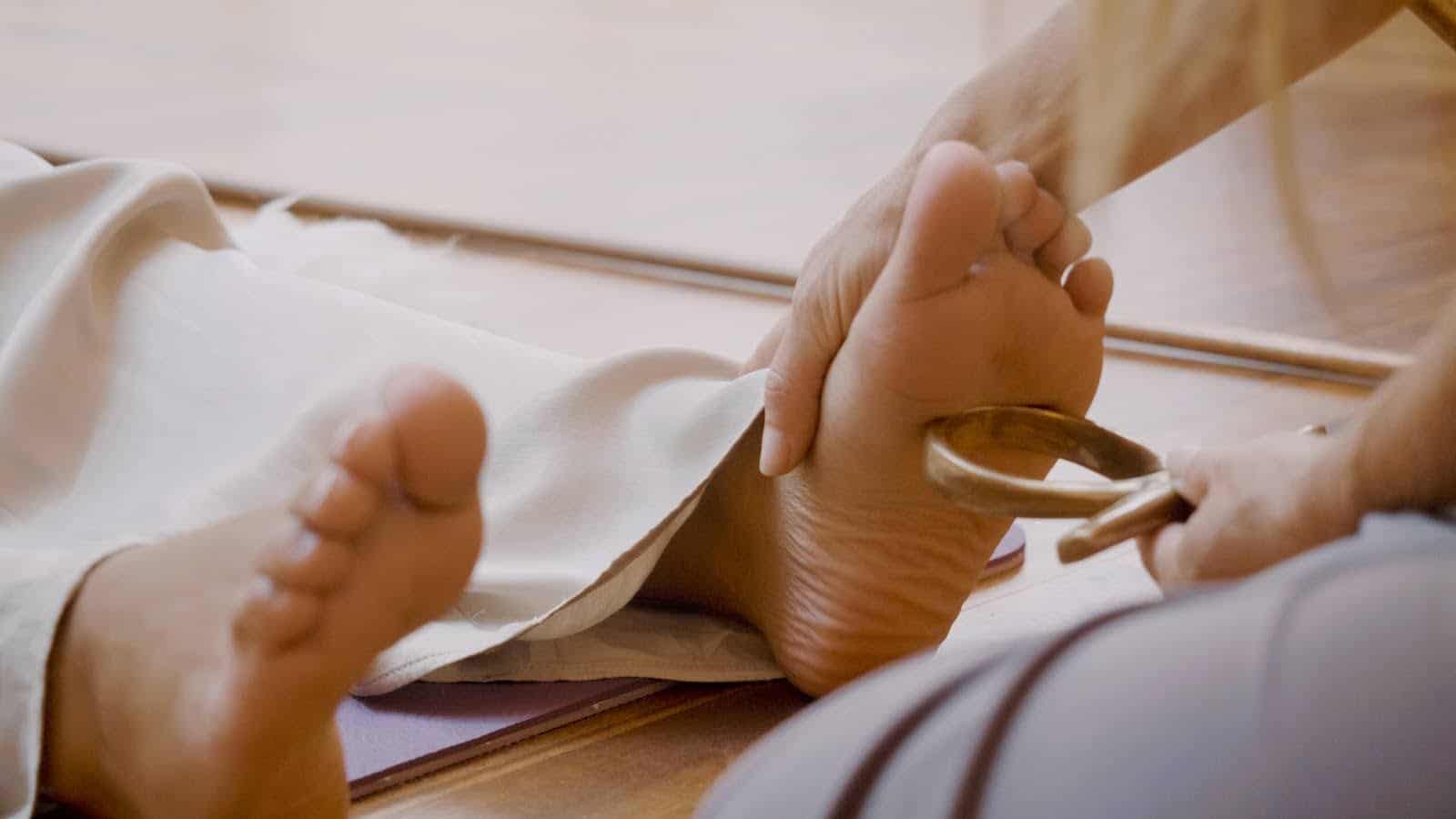 Persoon krijgt voetmassage voor ontspanning en energiebalans.