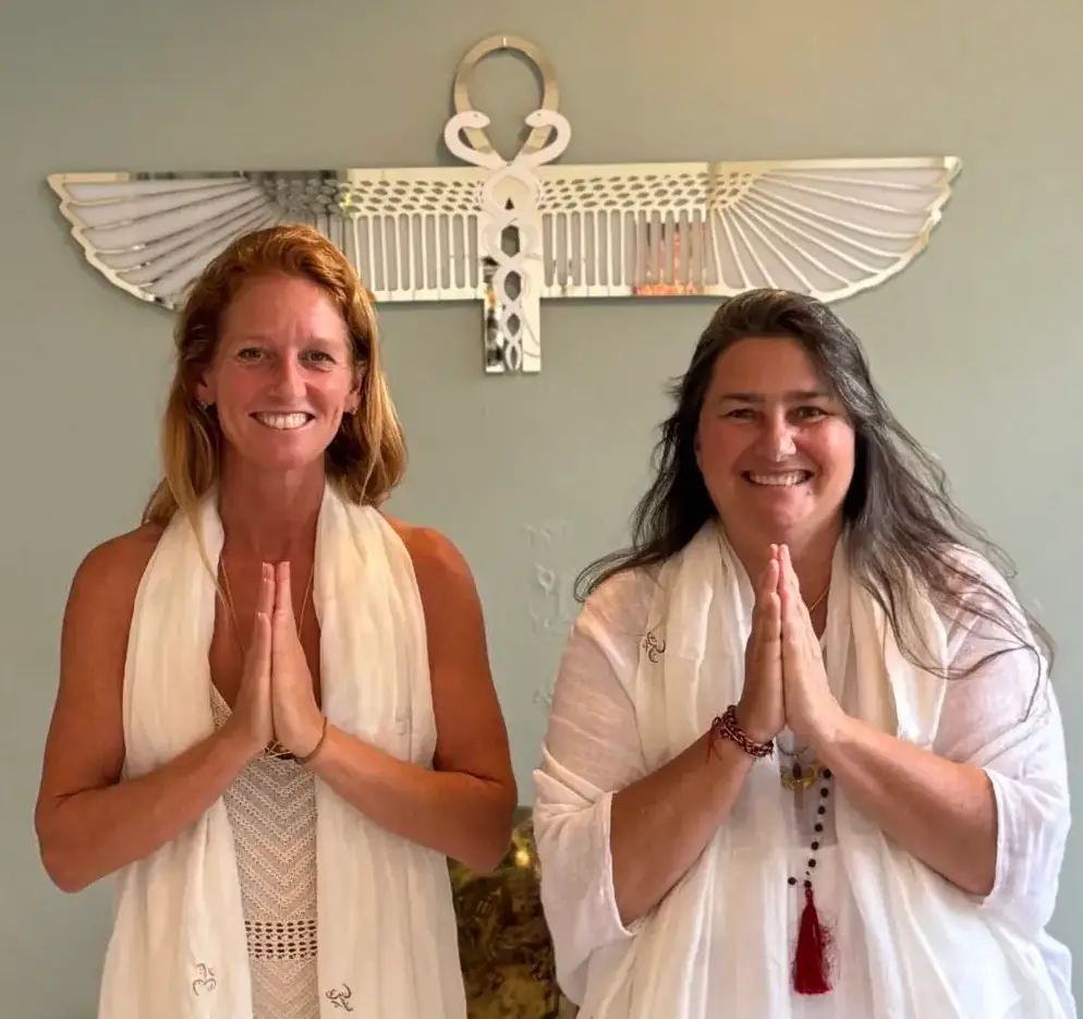 Twee vrouwen in meditatiehouding voor spirituele energie en bewustzijn.